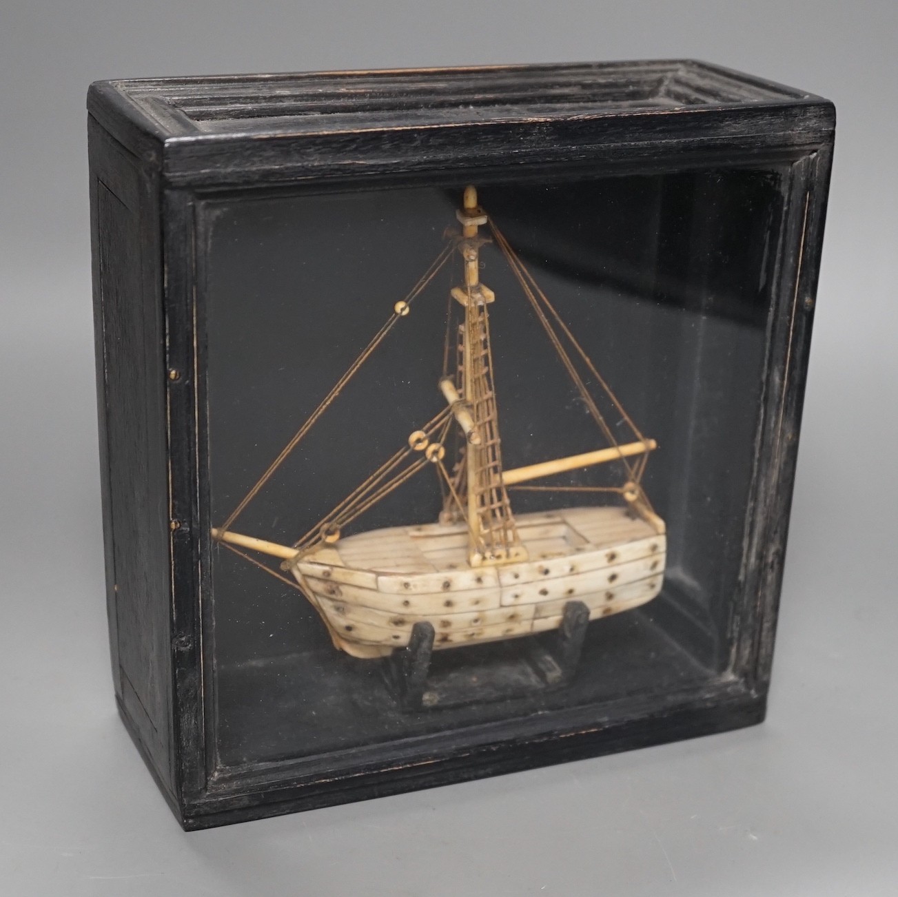 A cased bone Napoleonic style, carved prisoner-of-war ship, 18cms wide x 18.5cms high